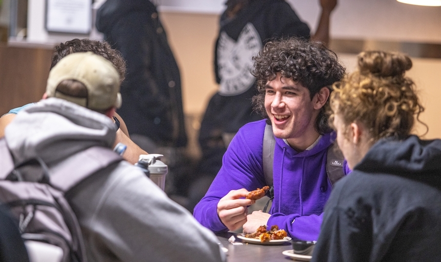 friends sitting at a table eating wings