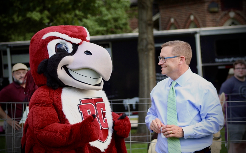 President Shusok standing with Rooney smiling. 