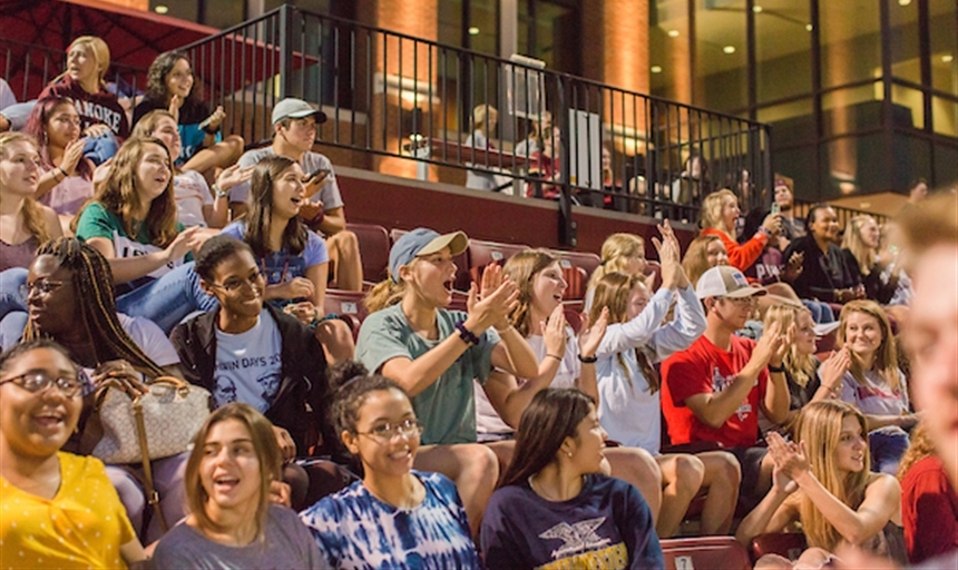 students cheering on a sports team in the stands