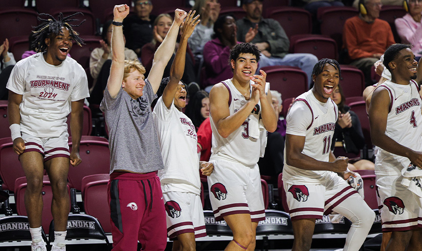 Basketball players jump and cheer in celebration of a good play during a game