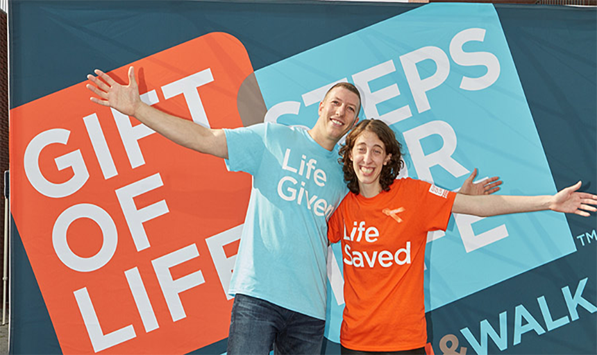 Two people posing for picture, one person wearing a shirt saying "life given" then other wearing a shirt saying "life saved"