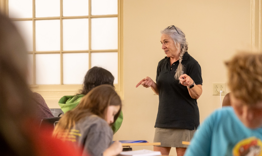 A teacher addressing students in a classroom
