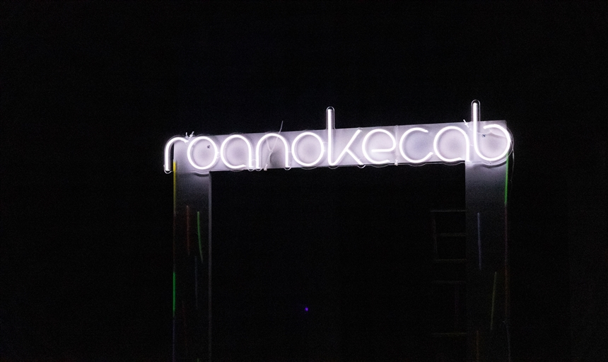 white neon sign that says Roanoke CAB in lowercase letters