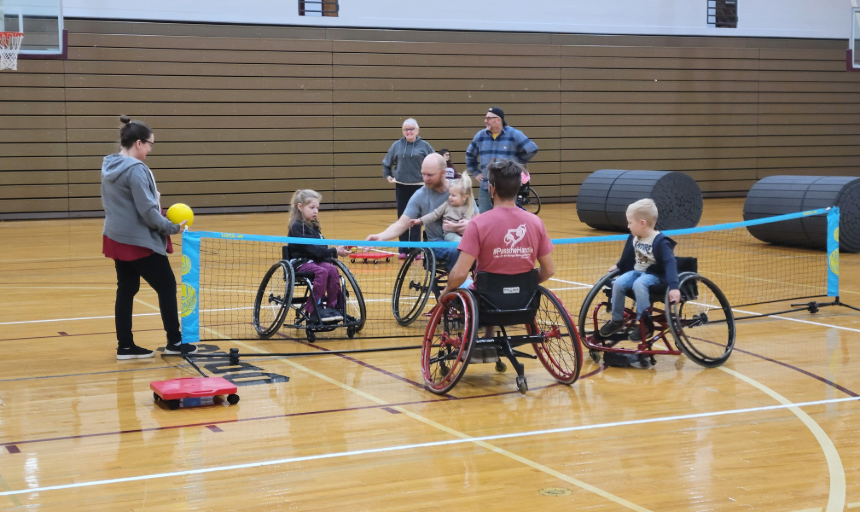 kids and adults playing badminton while in wheelchairs.