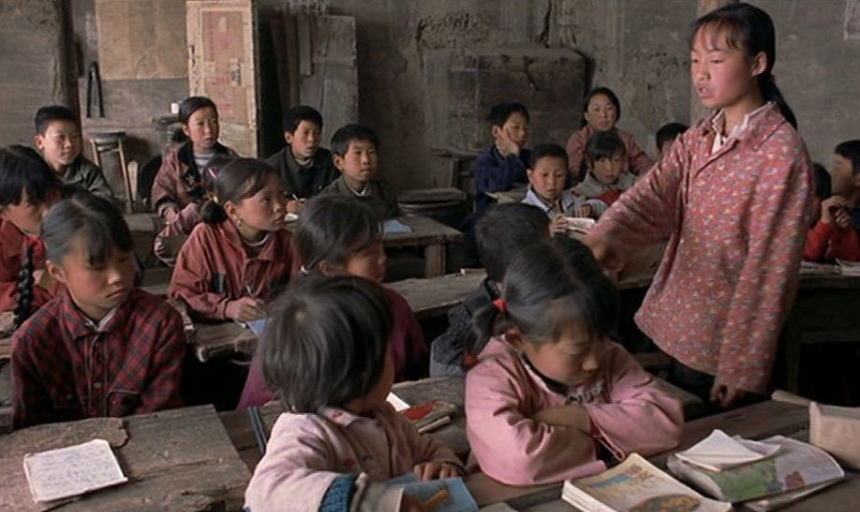 A young girl addresses a classroom full of students