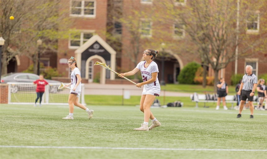 Photo of a Roanoke Women's Lacrosse player looking down the field while holding her stick
