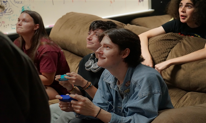 two men holding controllers paying mario kart 