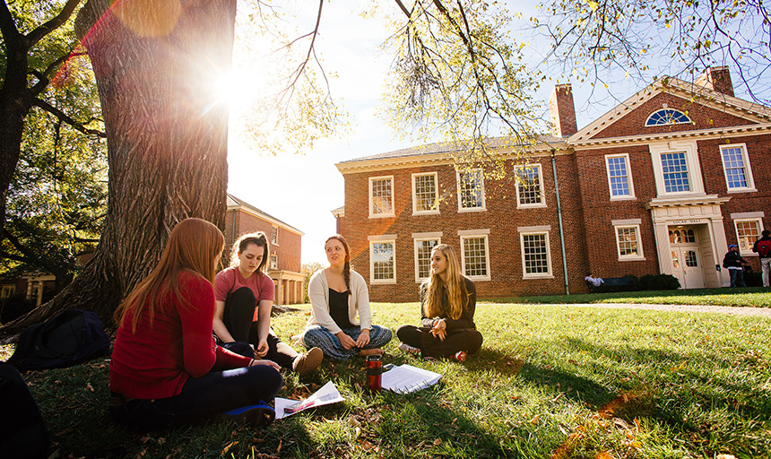 students sitting outside doing homework