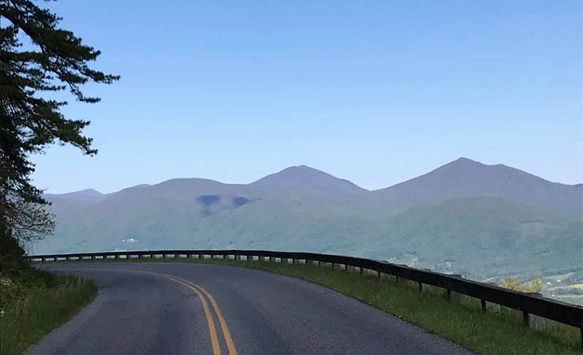 view of road turning and mountains in the distance ahead