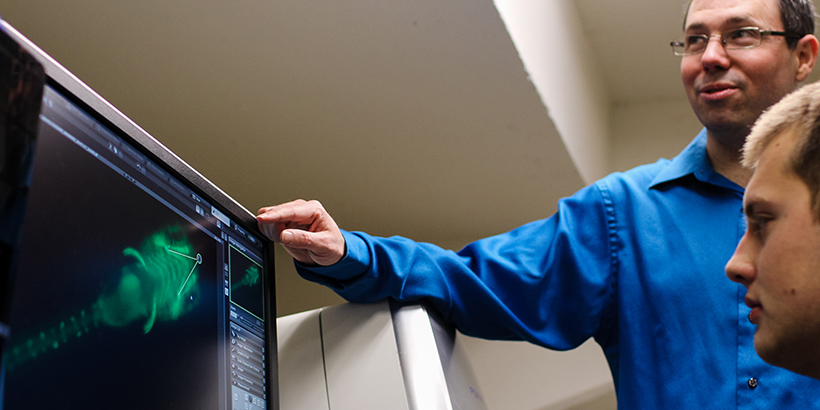 Chris Lassiter looking at a computer model with a student