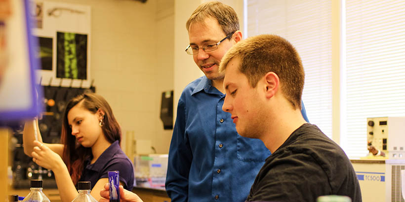 Chris Lassiter talking with students doing research