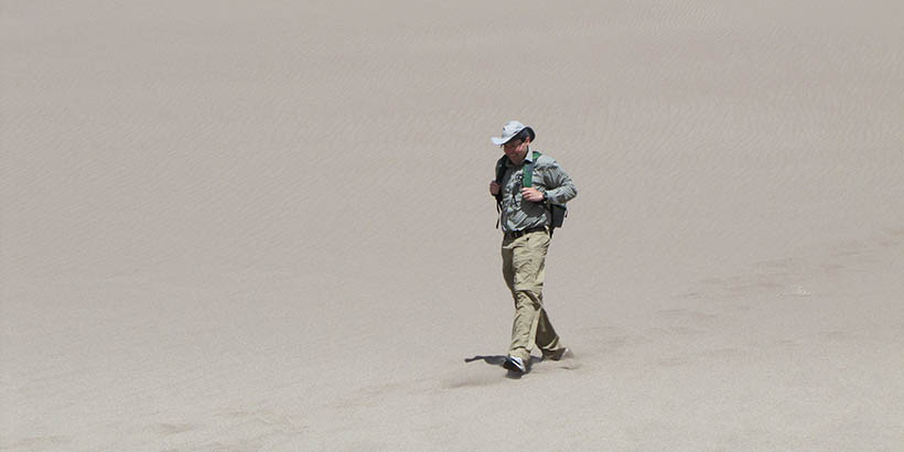 Chris Lassiter walking through the great sand dunes