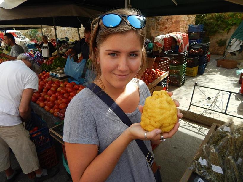 Student holding fruit in a marketplace