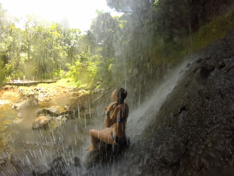 Student sitting under a small waterfall