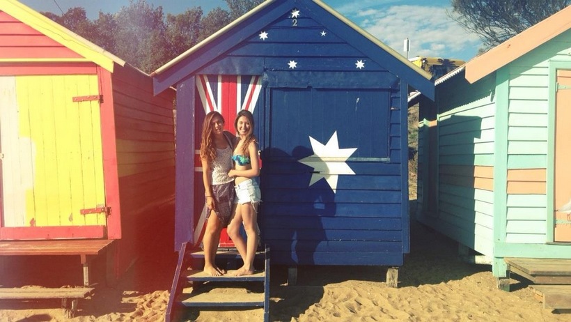 Students posing in front of a small house decorated with the Union Jack