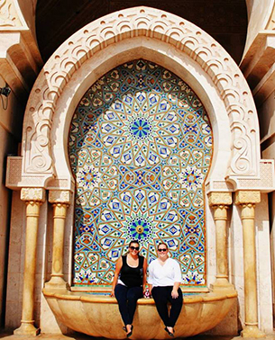 Students sitting by a large mosaic