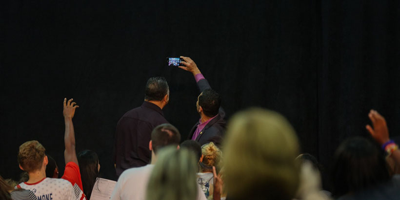 Jesse Jackson and Sam Rasoul take a selfie with audience members.