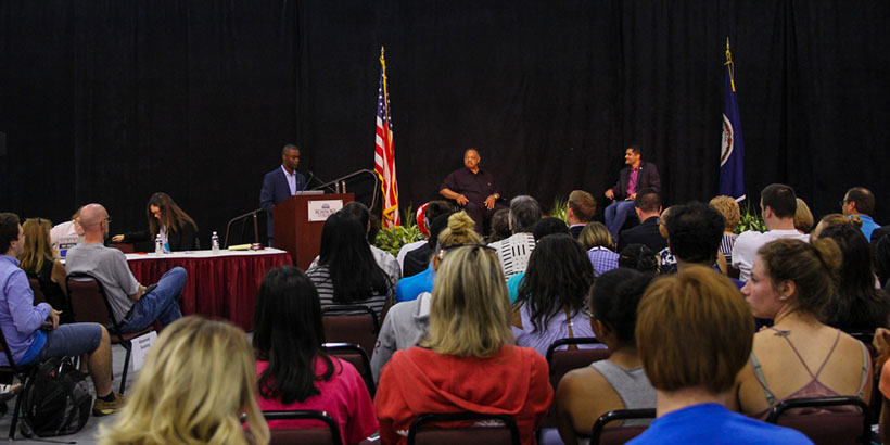 Audience members hear from Myles Cooper, Jesse Jackson and Sam Rasoul.