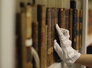 Gloved hand touching old books