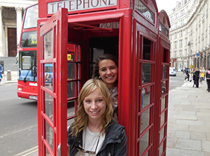 Students posing in a classic London phone booth
