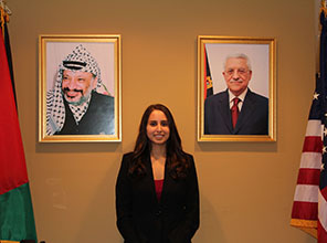 Student posing by portraits