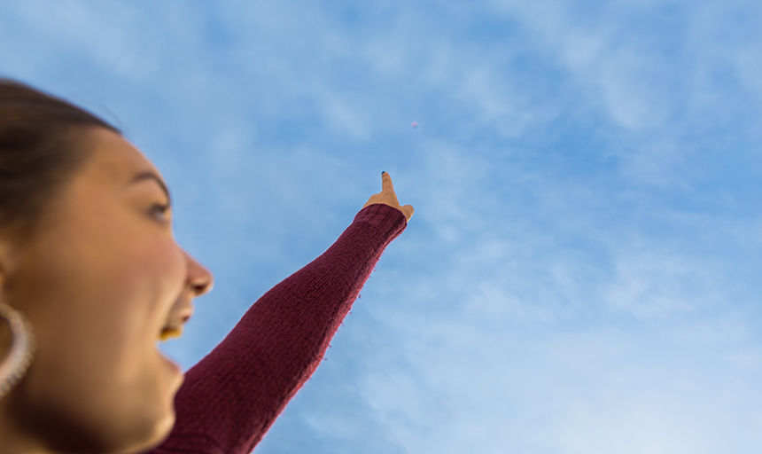 Student pointing at drone in the sky