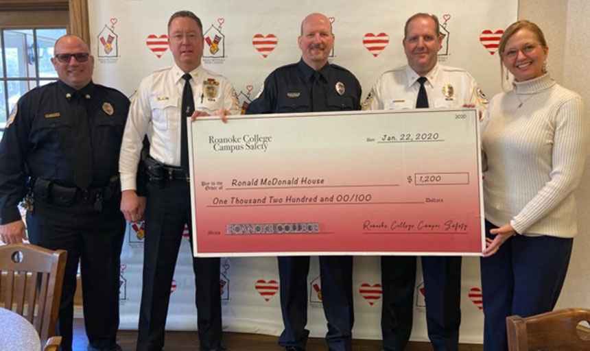 campus safety officers present check to Ronald McDonald House staff