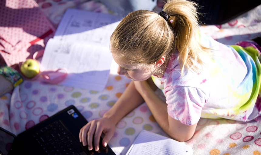 Girl working on laptop in bed