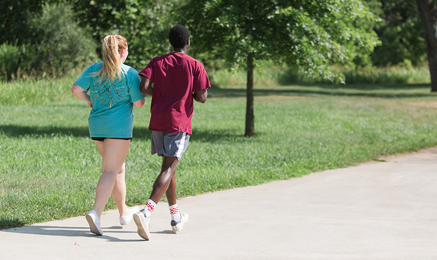 Two students run on the greenway