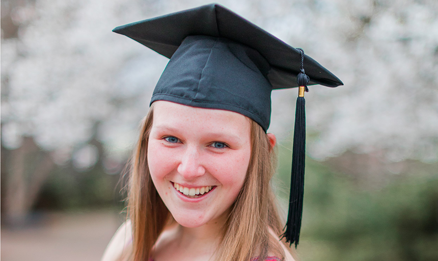 Female student in graduation cap smiling