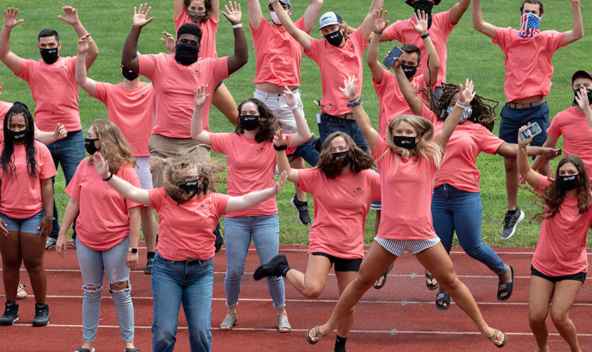 RAs wearing face coverings leaping in celebration