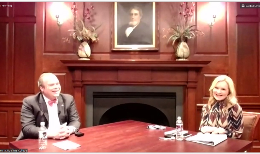 Two people laugh with each other in ornate board room