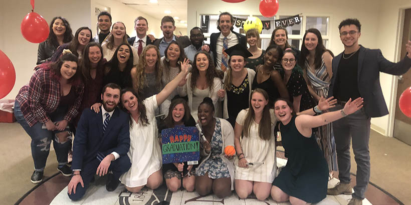 Students posing for a group photo at their mock commencement