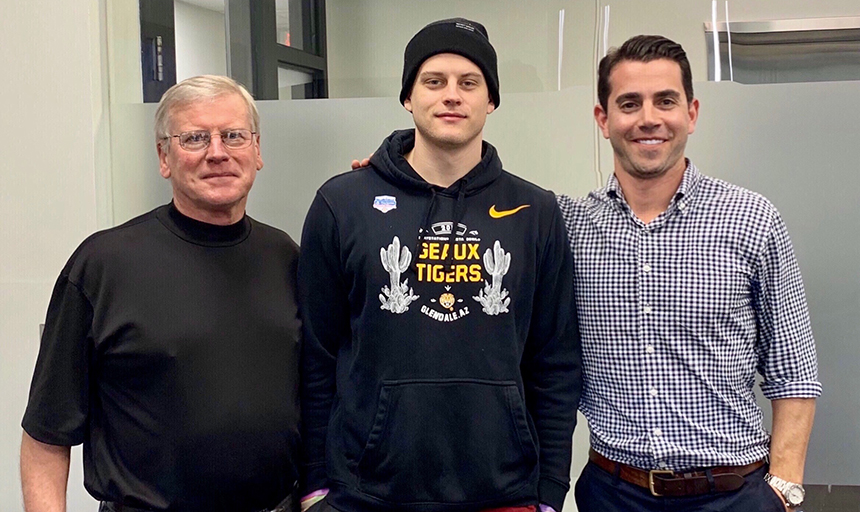 Three men, including quarterback Joe Burrow, smiling