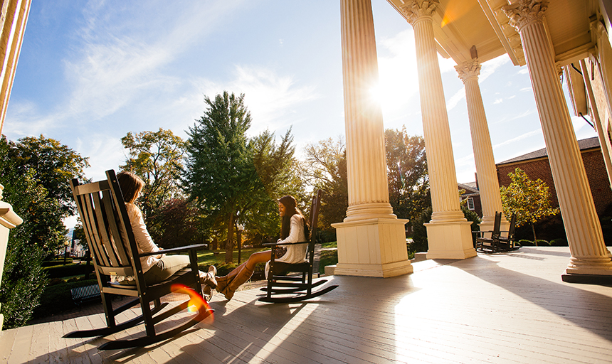 Students sitting on sunny porch