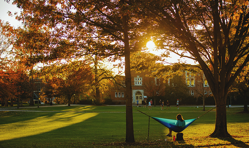 Person in a hammock on the quad during sunset