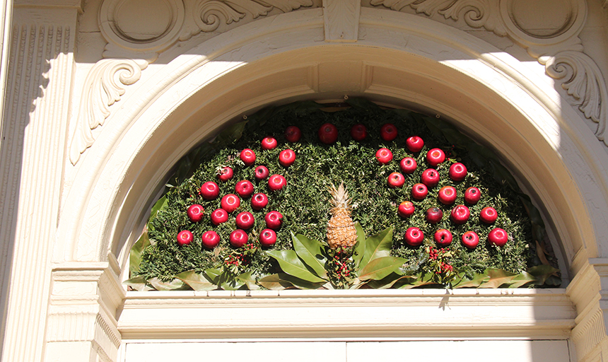 doorway decorated for holidays with pineapple and apples