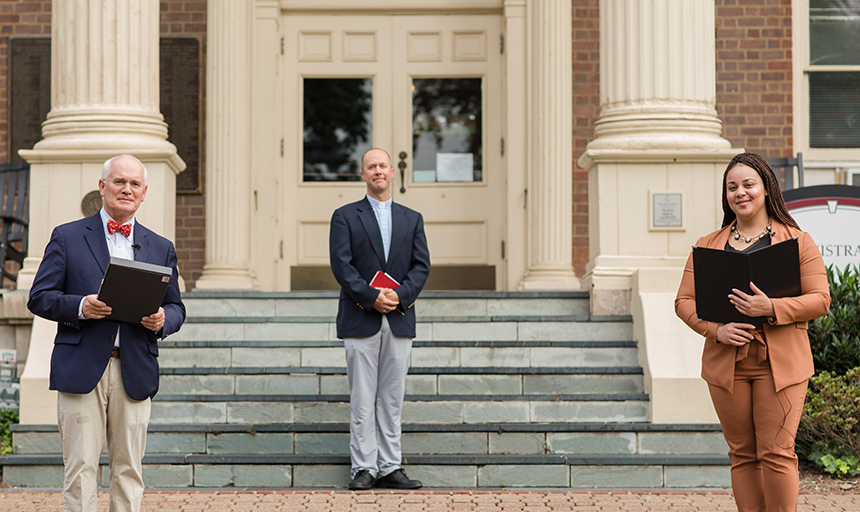 Three people standing in front of steps