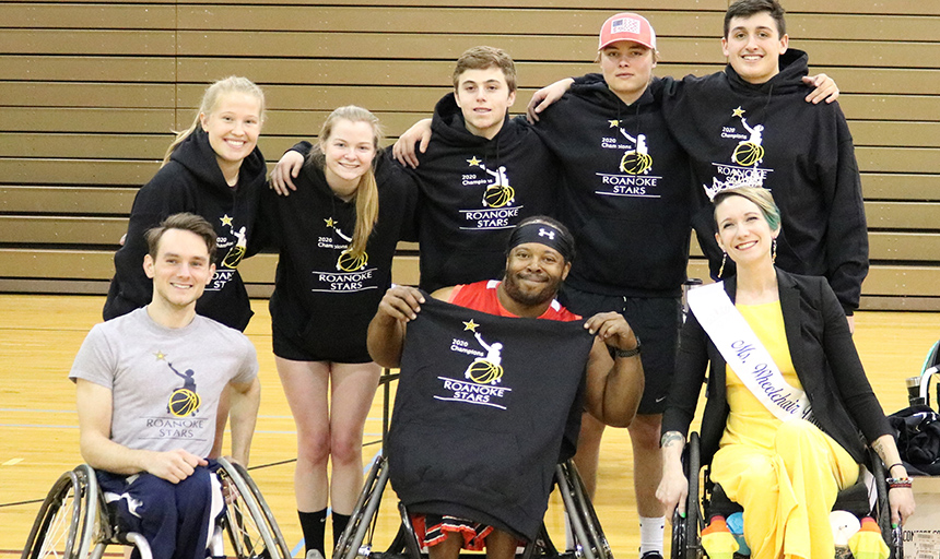 Students posing with members of the wheelchair basketball team
