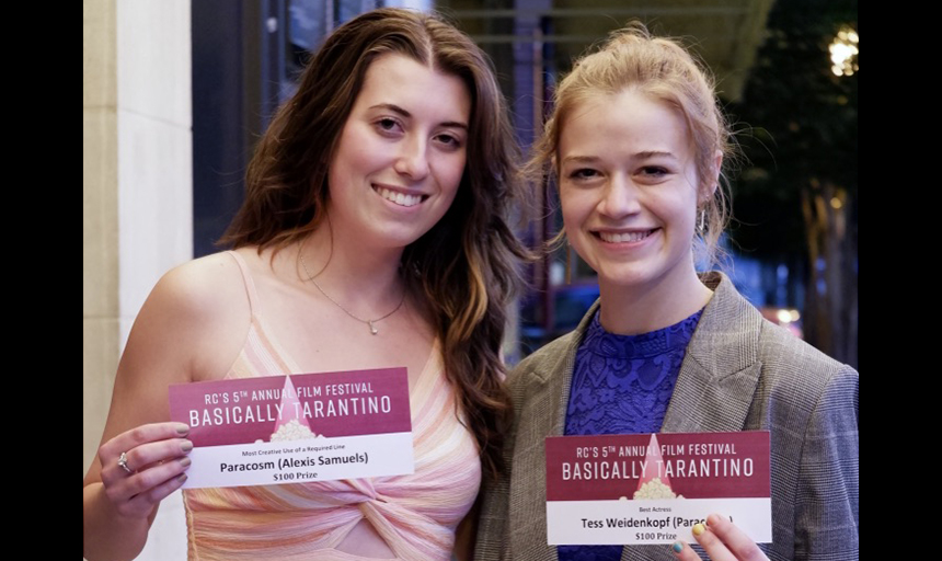 Two smiling women holding awards