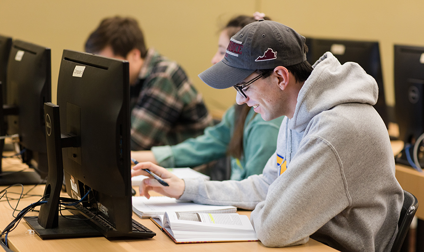 Student at computer, smiling