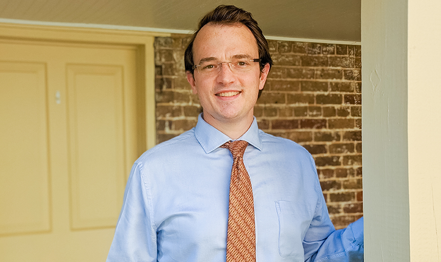 Man in tie smiling on porch