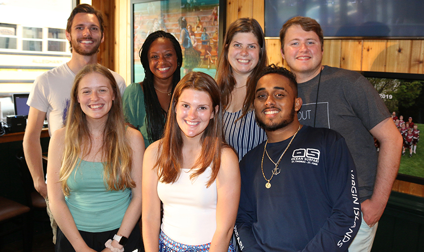 Seven students standing together and smiling