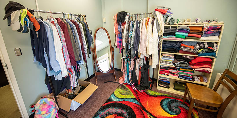 A room full of shelves of clothing and clothing on hangers