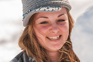 woman smiling in the snow with snowman