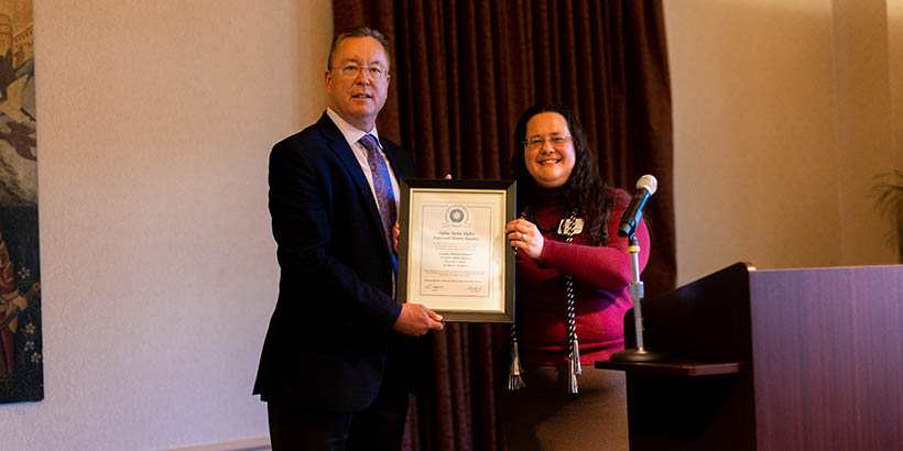 Tom Rambo and another individual holding up a framed certificate