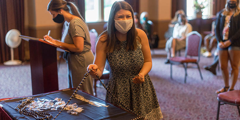 A student picking up her honor cords