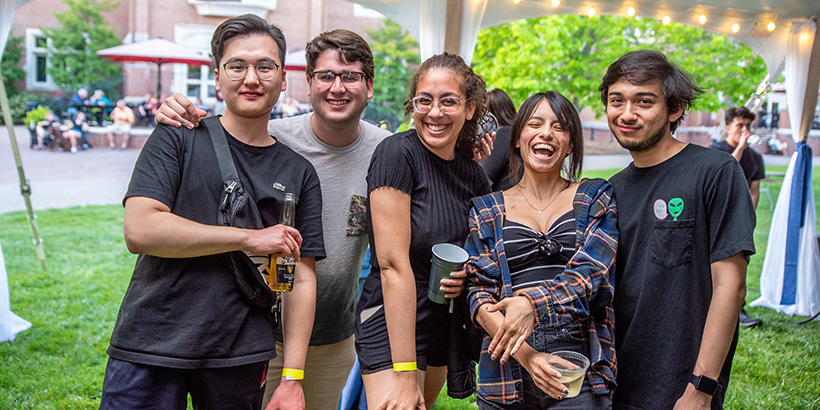 5 people stand together and smile for the camera