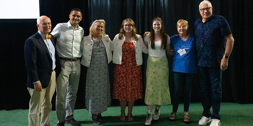 Seven people stand side by side