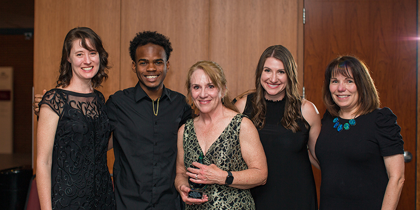 five people holding award